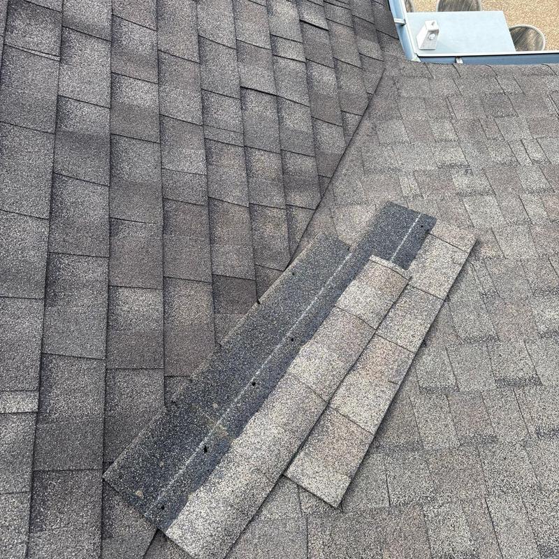 Asphalt roof shingles with visible hail damage and wear