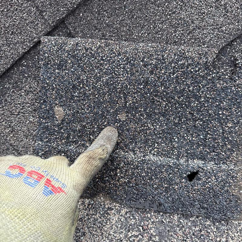 Asphalt shingle with hail damage and puncture hole