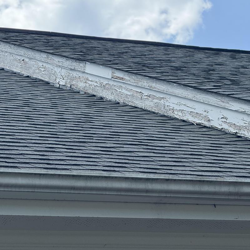 Exterior trim with peeling paint on roof peak Exterior trim with peeling paint on roof peak