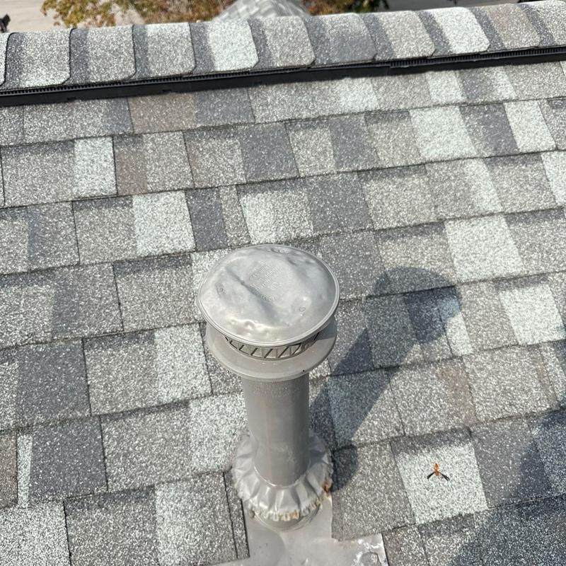 Roof vent pipe with hail dent damage on shingles