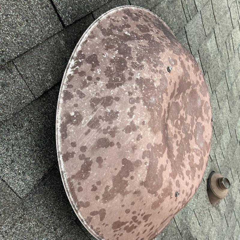 Satellite dish on shingle roof with discoloration spots