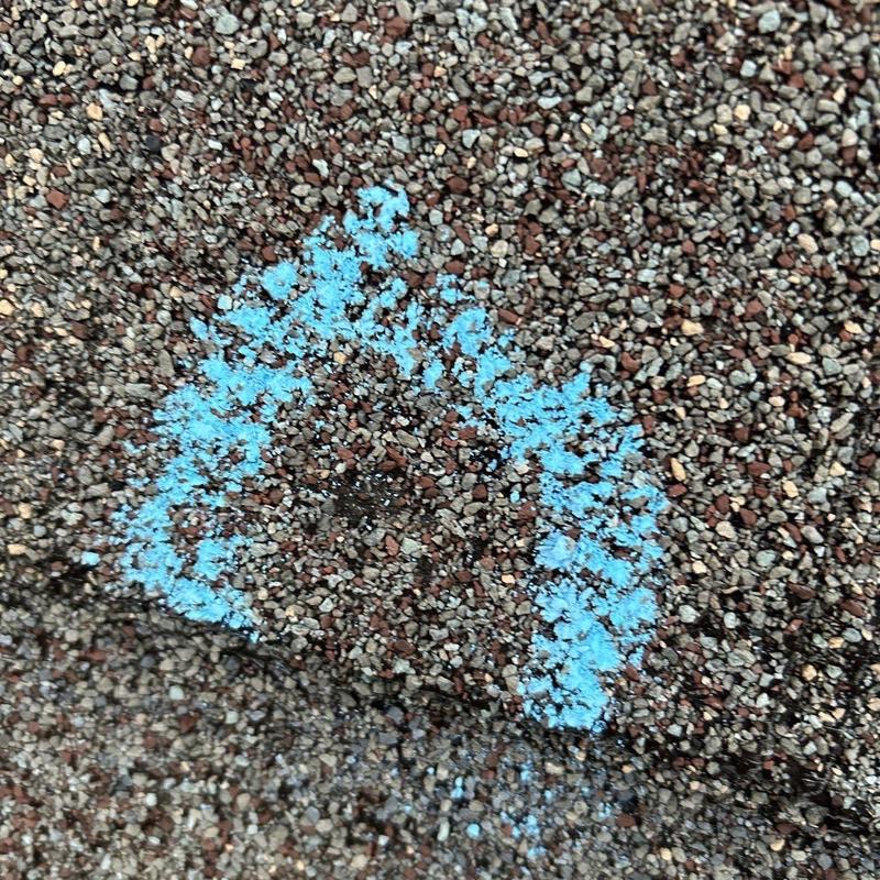 Roof shingles with marked hail damage spot