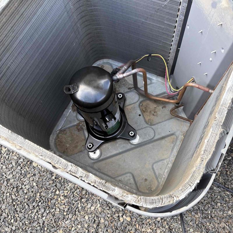 HVAC compressor unit inside metal condenser coil housing