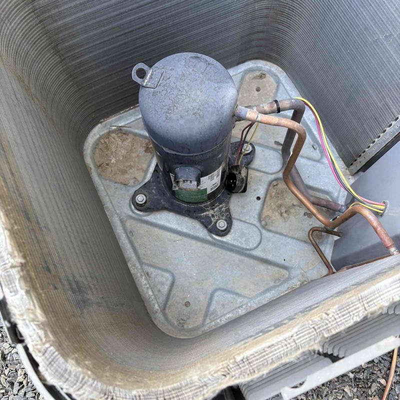 Compressor unit inside HVAC condenser coil with wiring