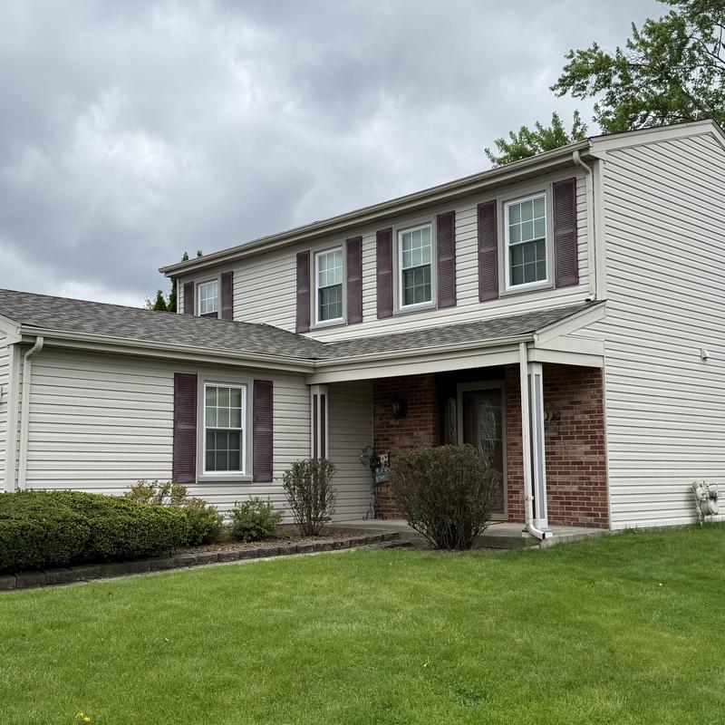 Asphalt shingle roofs with clean gutters on house