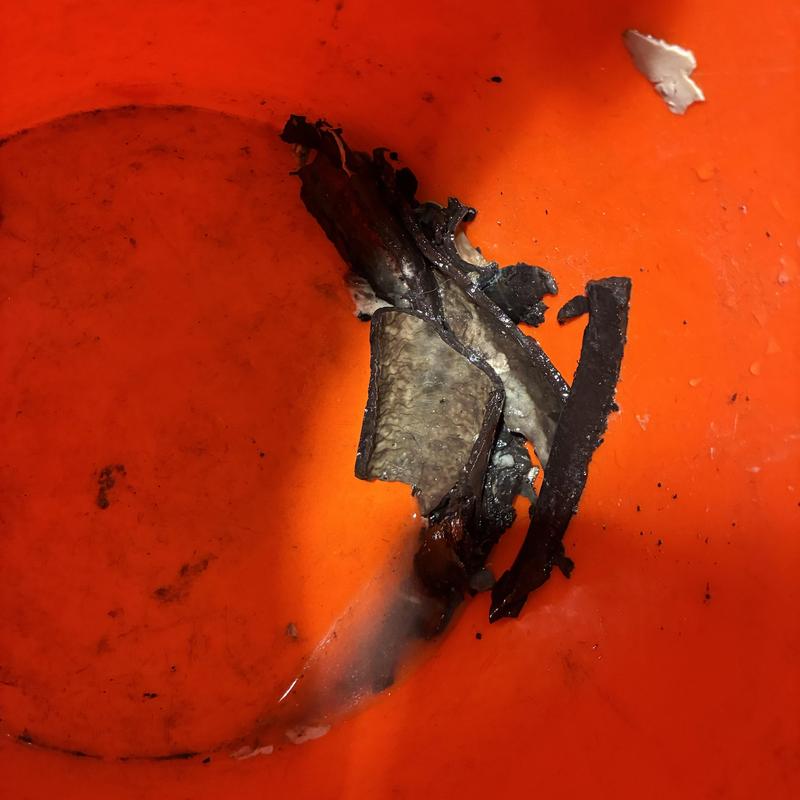 Bathroom sink drain clog debris in orange bucket