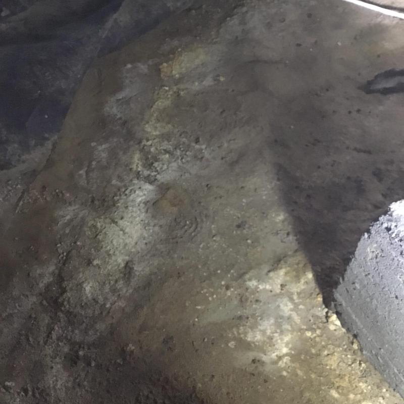 Crawl space floor with water damage and moisture