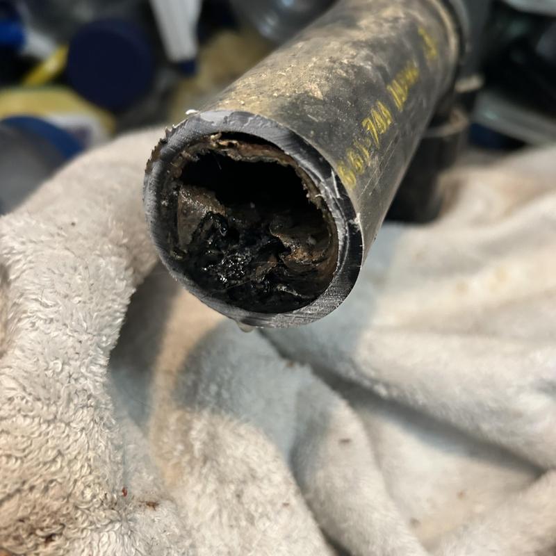 Clogged kitchen sink drain pipe with debris buildup