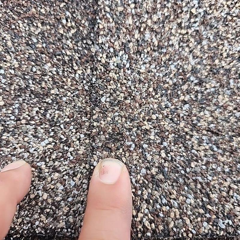 Shingle roof granules with hail damage close-up Shingle roof granules with hail damage close-up
