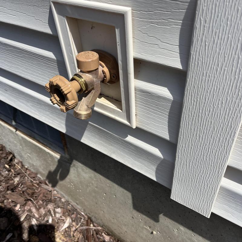 Outdoor hose bib installation on home siding with water check