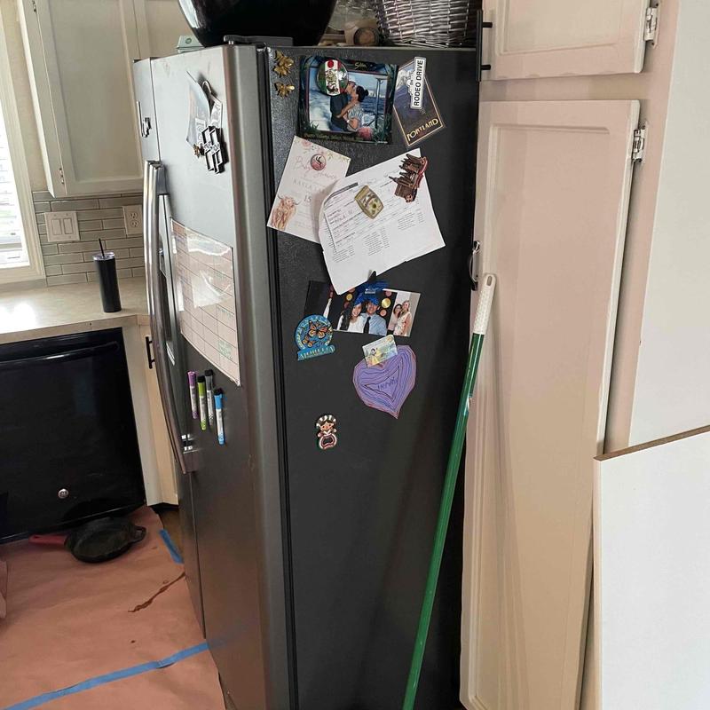 Refrigerator with magnets and notes in kitchen corner