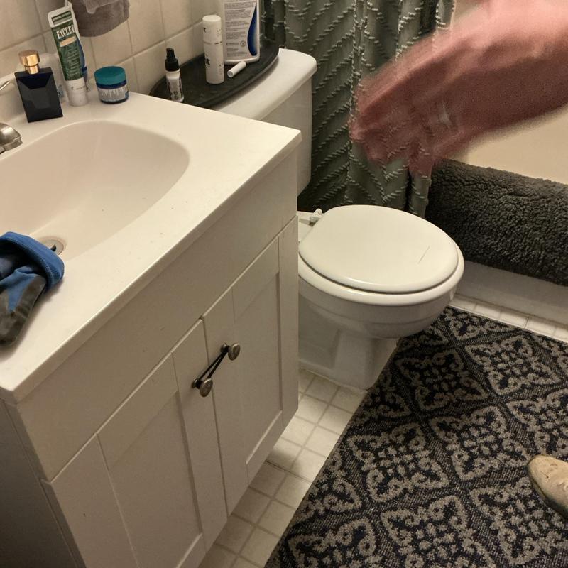 ADA height elongated toilet with closed lid in bathroom