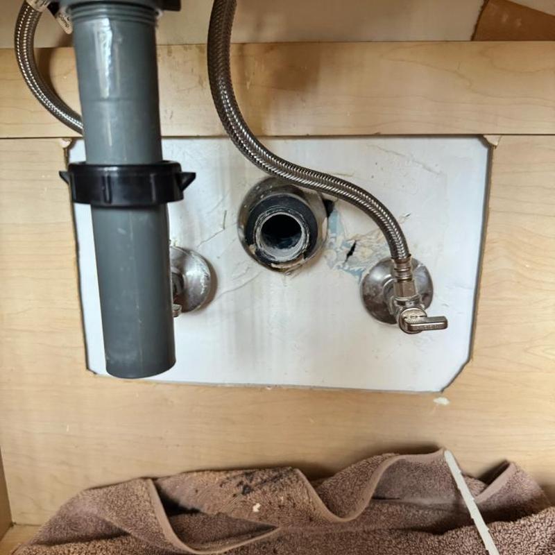 Bathroom sink drain pipe and water supply valves under sink