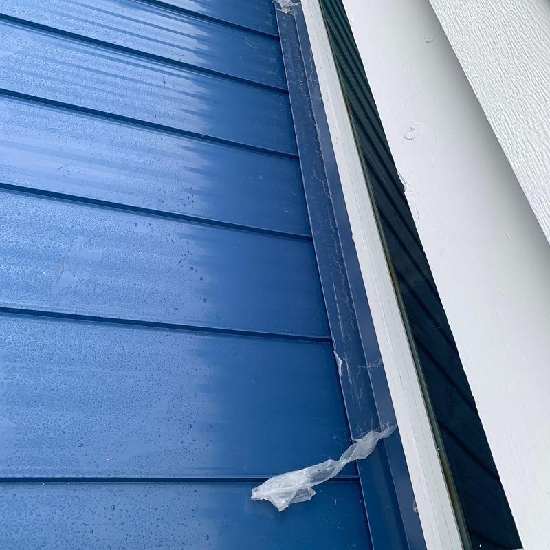 Aluminum standing seam roof panel near window trim
