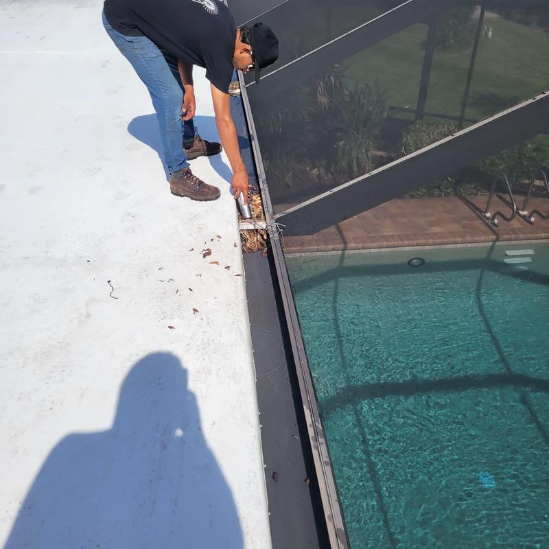 Pool cage gutter debris removal on flat roof edge