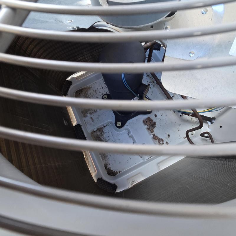 AC condenser coil and compressor interior with dirt debris