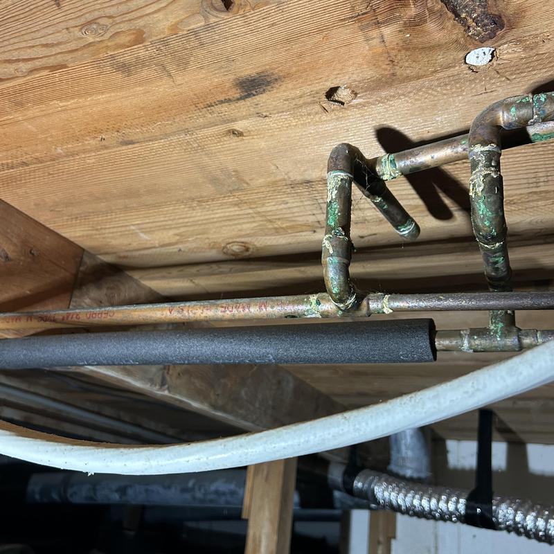 Copper water pipes with corrosion in crawlspace ceiling