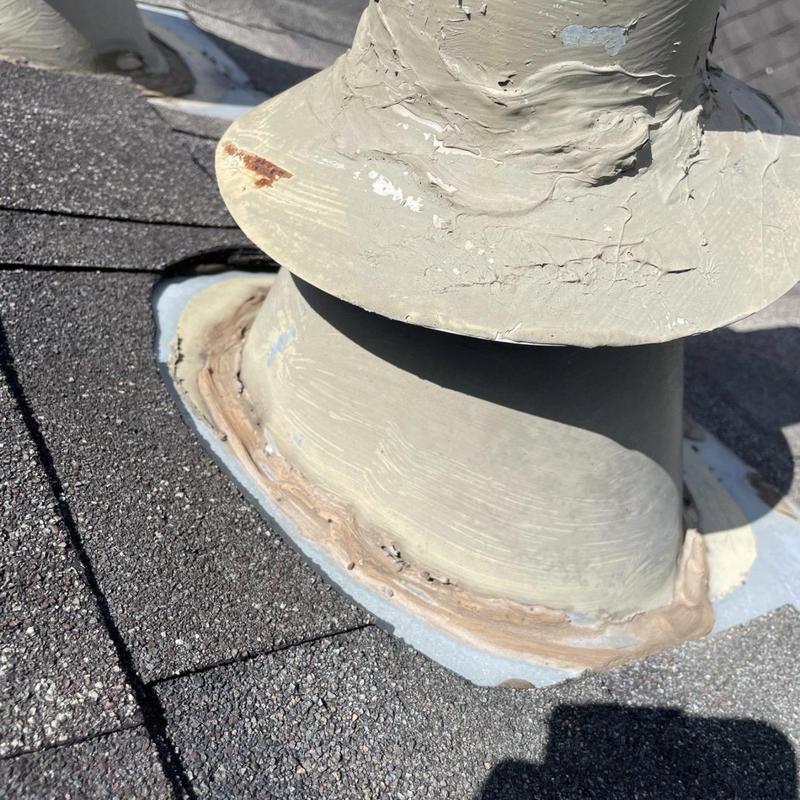 Plumbing vent pipe flashing with cracked sealant on shingles Plumbing vent pipe flashing with cracked sealant on shingles