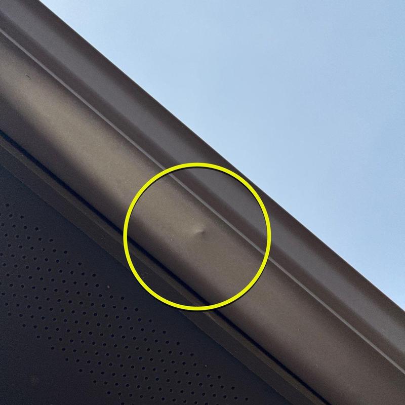Metal gutter dent with impact damage inspection mark