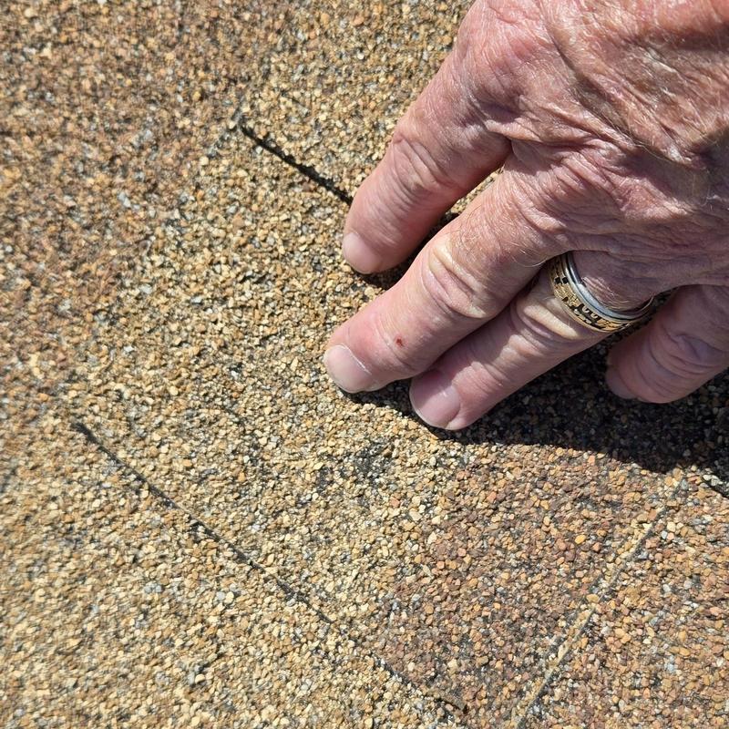 Asphalt roofing shingle hail damage inspection with hand