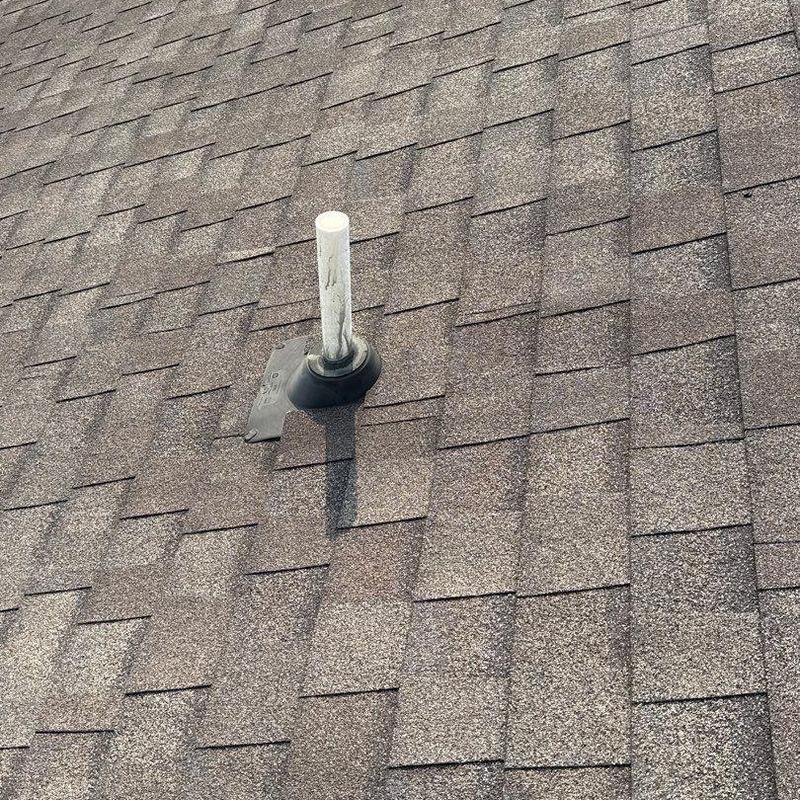 Roof vent flashing on asphalt shingle roof with hail damage