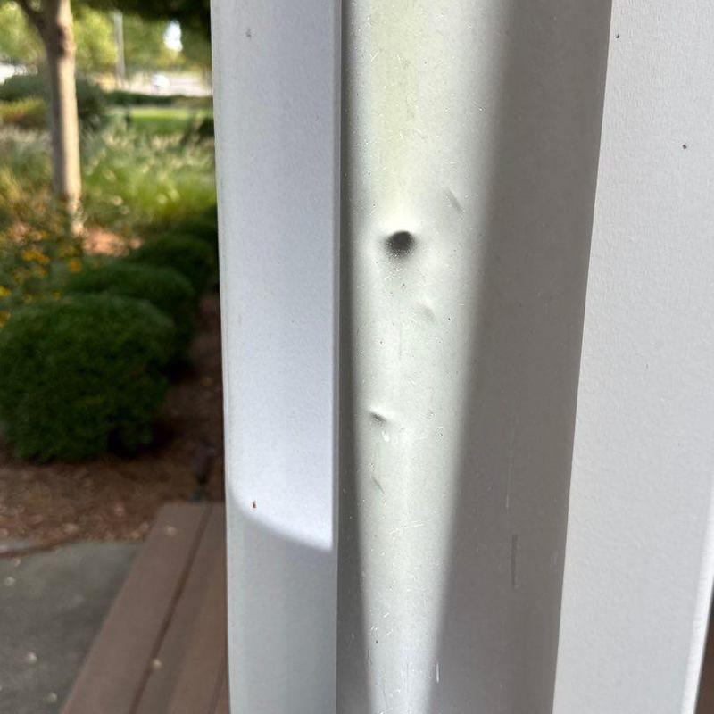 Metal trim with hail damage dents on exterior column