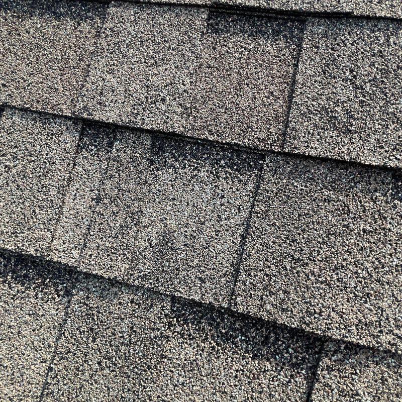 Asphalt roof shingles with hail damage close-up