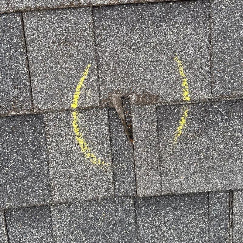 Asphalt shingles with hail damage marked in yellow