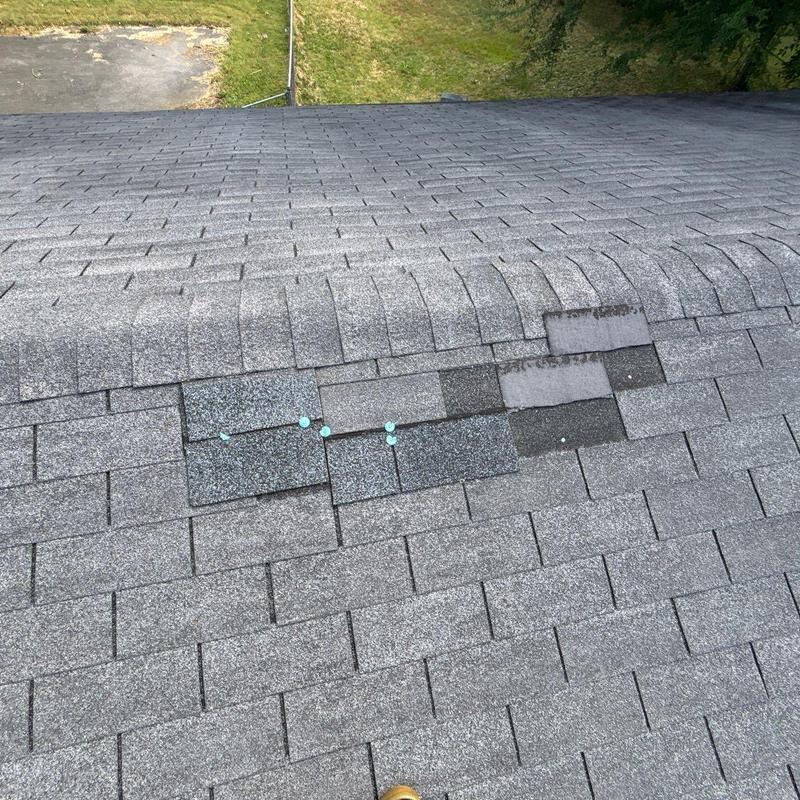 Asphalt roof shingles with patch installation and visible nails