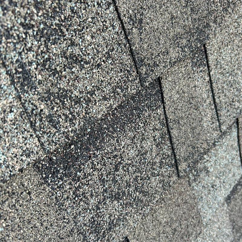 Asphalt roof shingles with visible hail damage close-up