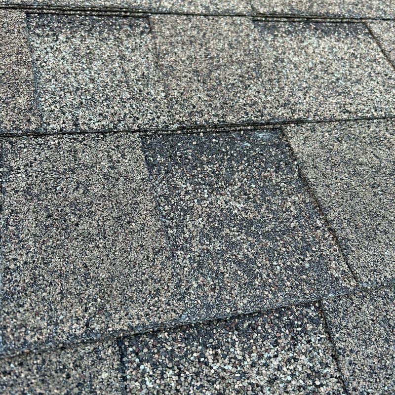 Asphalt shingle roof granule loss from hail damage close-up