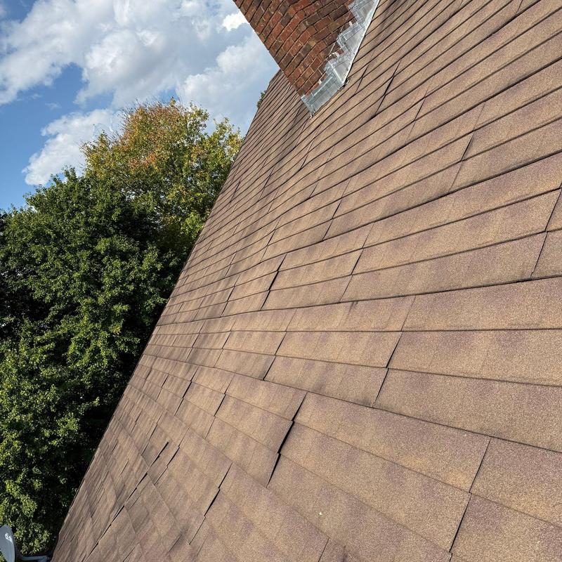 Asphalt roof shingles with hail damage and lifting