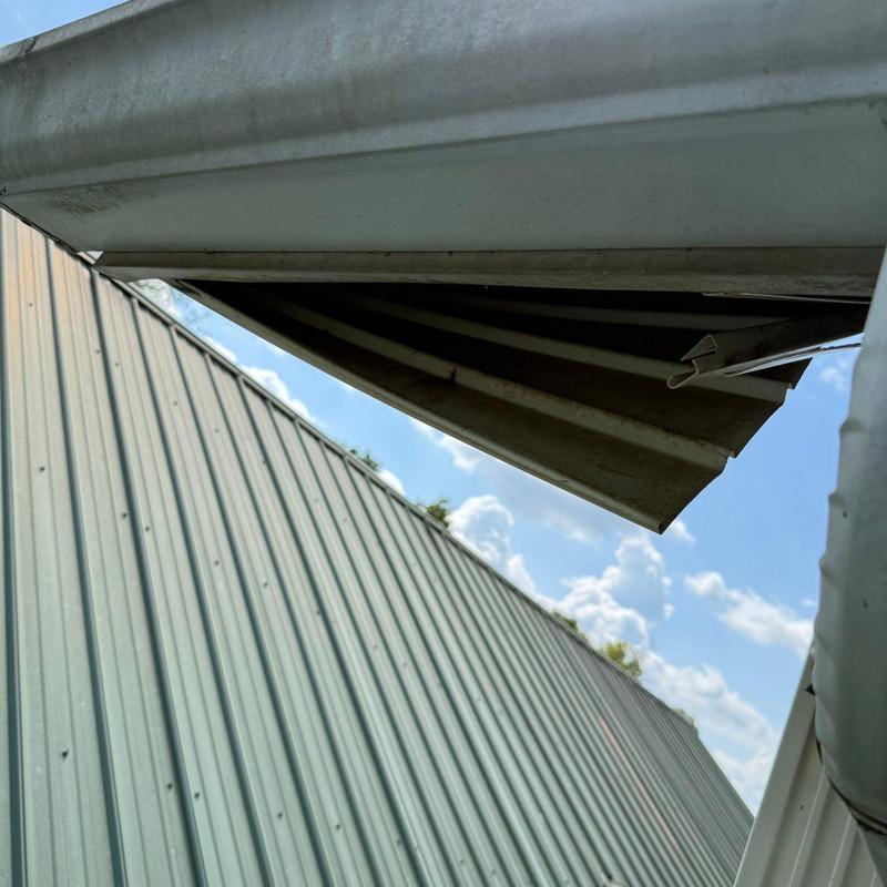 Metal roof panels with damaged ridge cap section