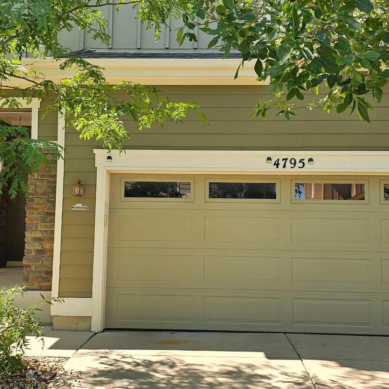 Garage door exterior with green siding and house number Garage door exterior with green siding and house number