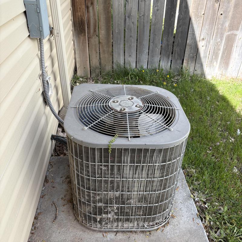 HVAC outdoor condenser unit by house siding