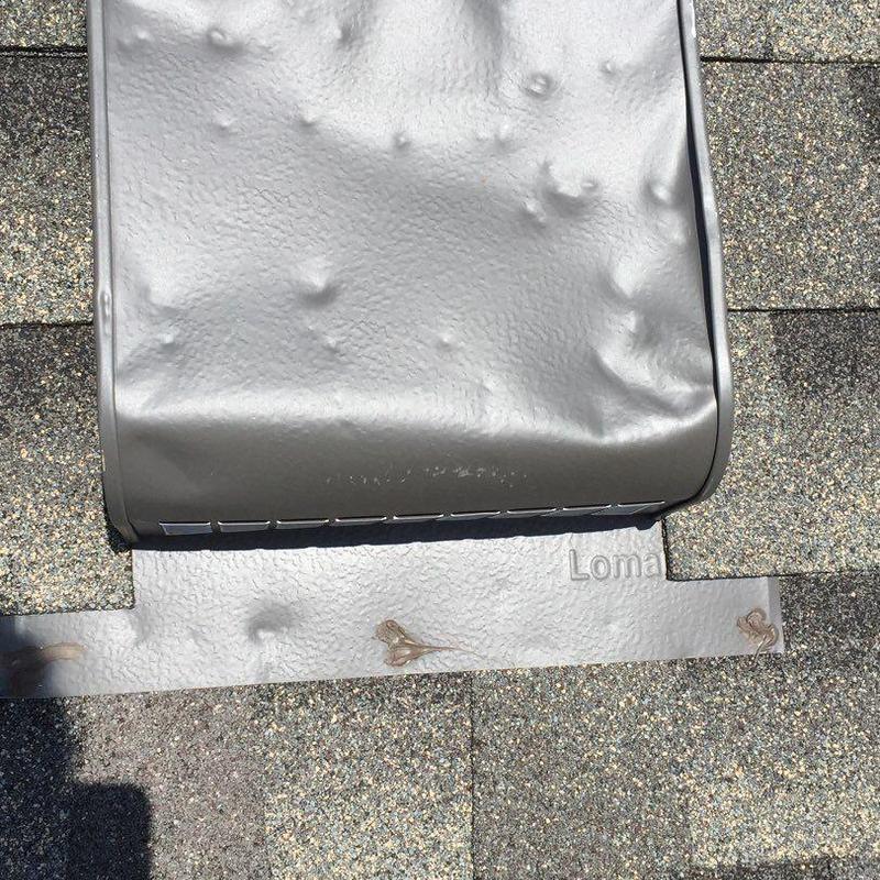 Roof flashing with hail dents on asphalt shingles