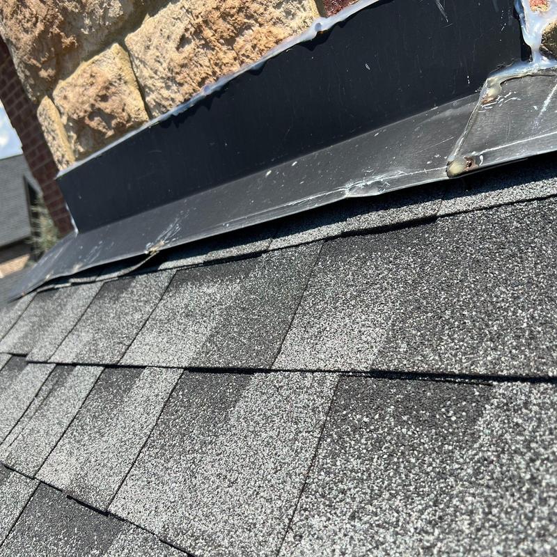 Roof shingles and metal flashing with hail damage