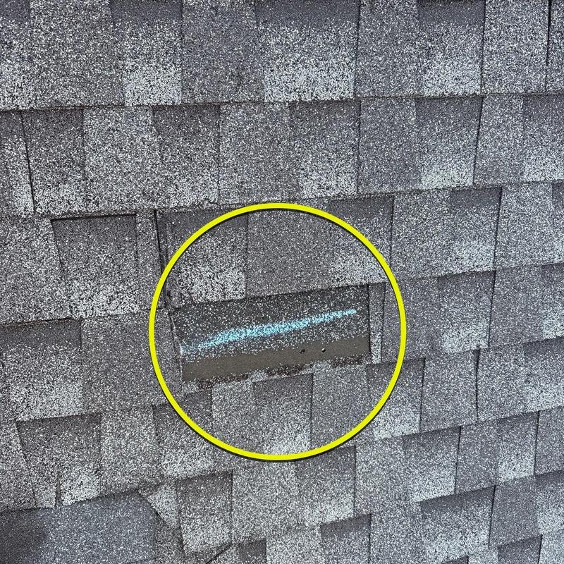 Roof shingles with hail damage marked in blue