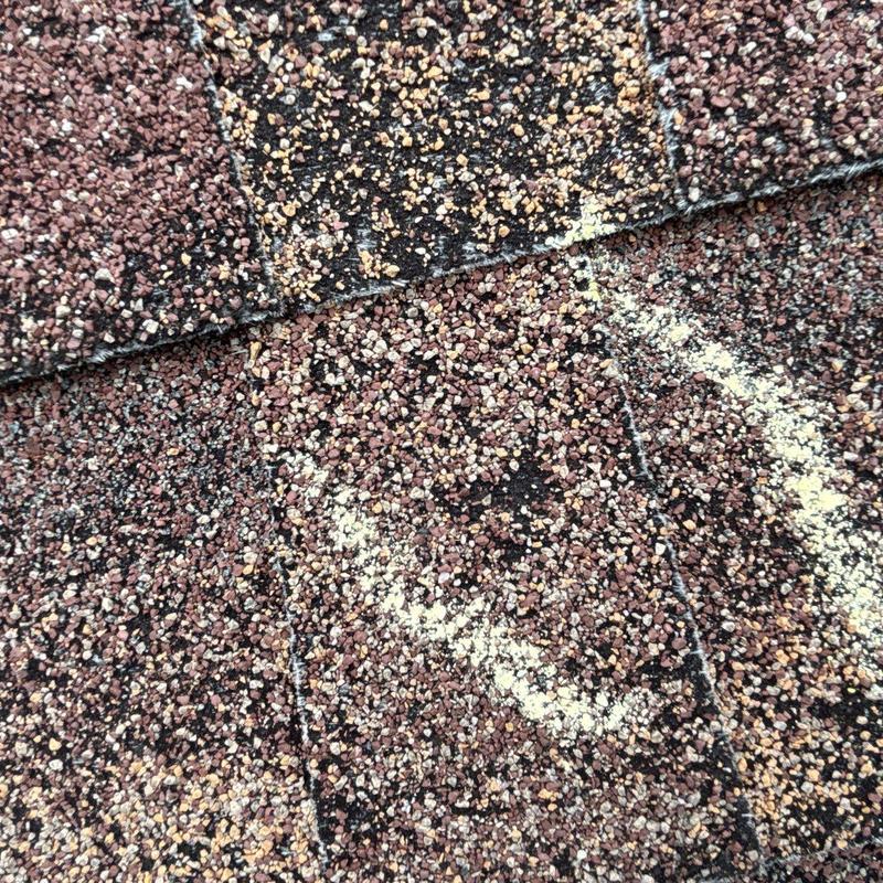 Roof shingles with hail damage marked for repair