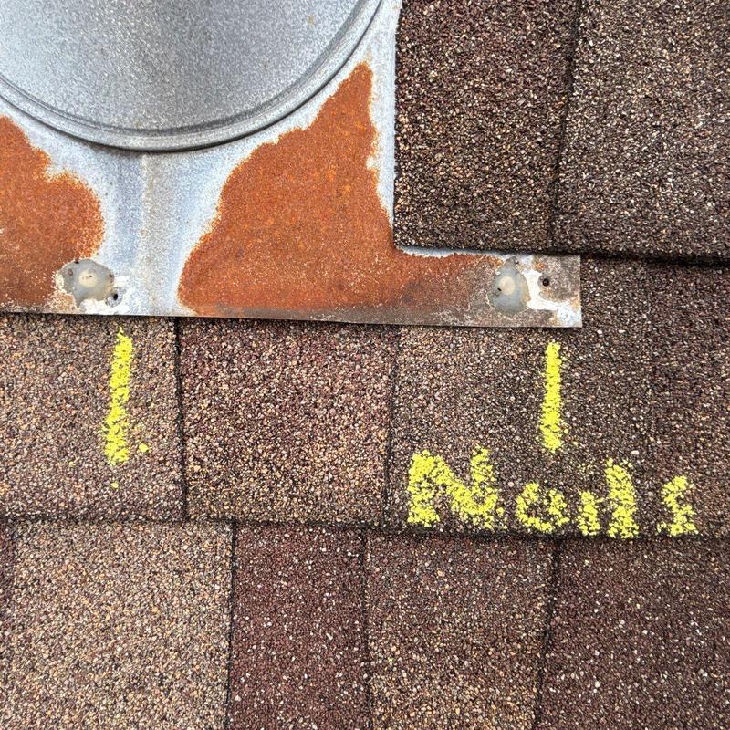 Roof flashing with rust and nail damage markings
