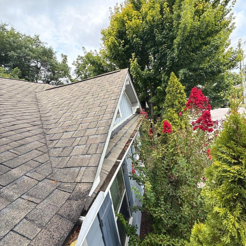 Roof shingles with hail damage near dormer window