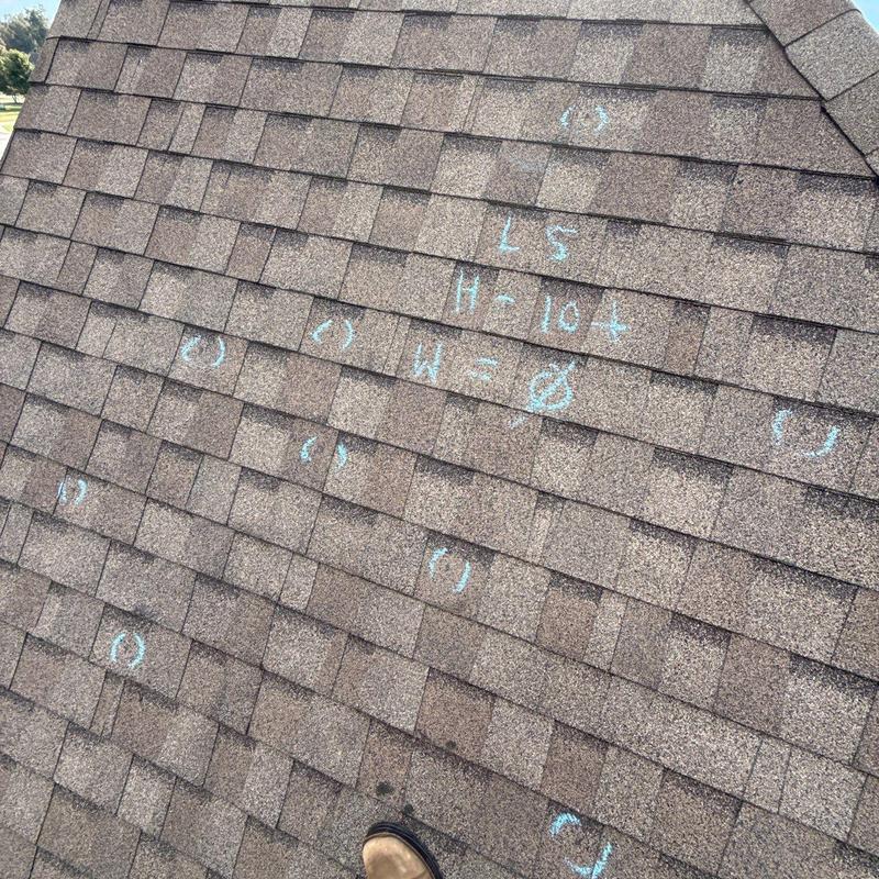 Asphalt roof shingles with chalk-marked hail damage