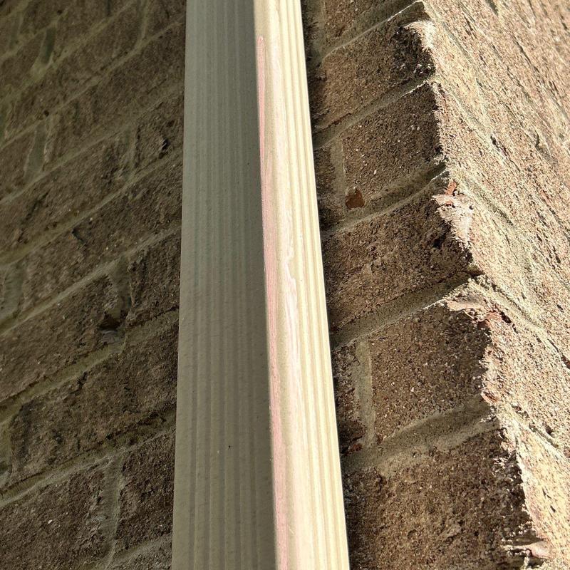 Downspout and brick wall exterior close-up