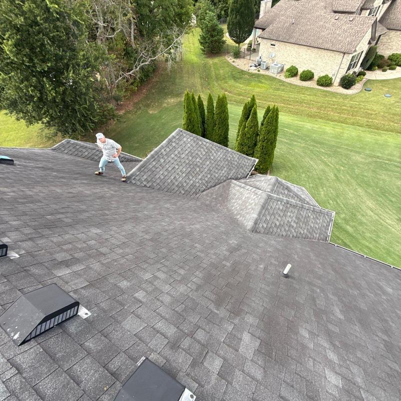 Asphalt shingle roof inspection with vents and worker