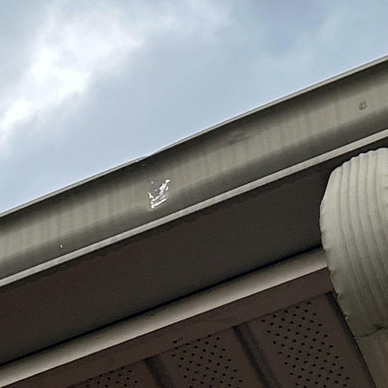 Metal gutter with hail damage dent on edge
