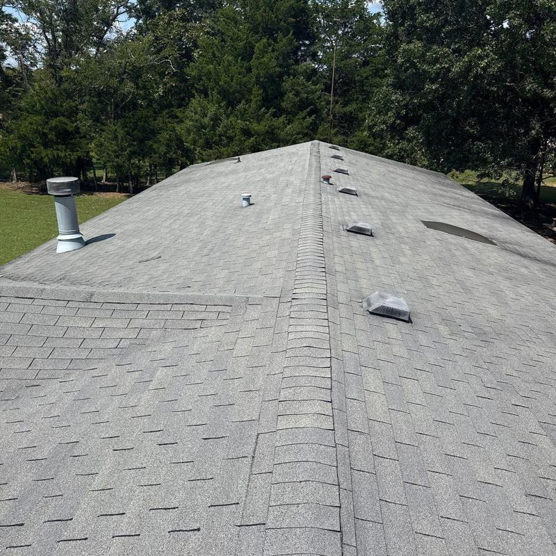 Asphalt shingle roof with ventilation pipes and ridge vents
