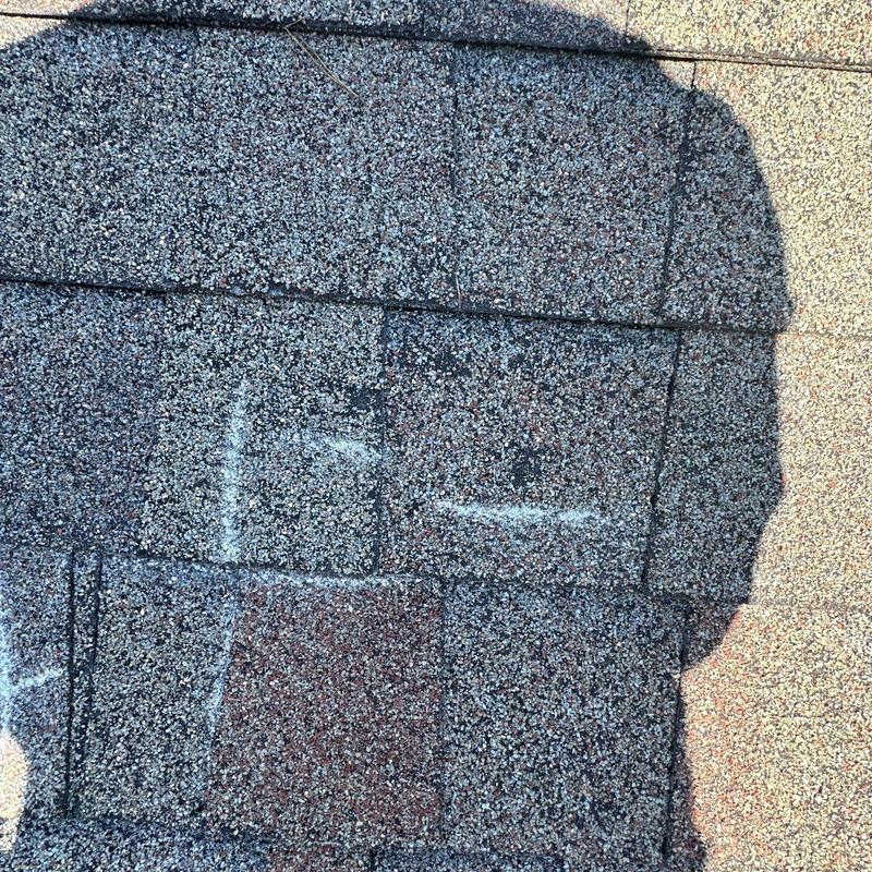 Asphalt shingles with hail damage marked in chalk
