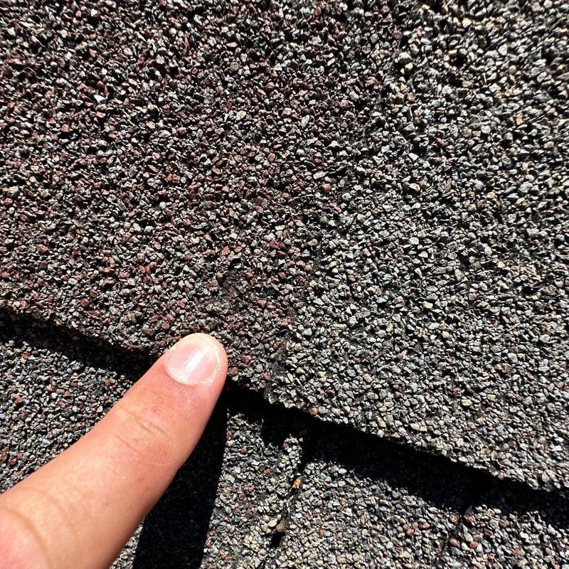 Asphalt shingle roof granule loss from hail damage close-up