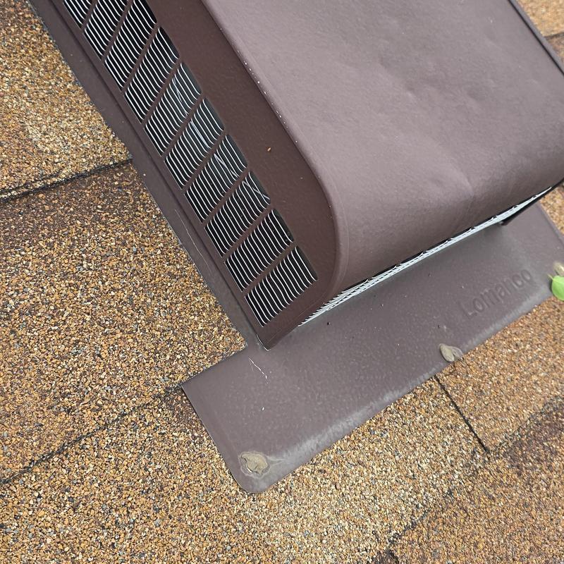 Roof vent with visible hail damage on shingles