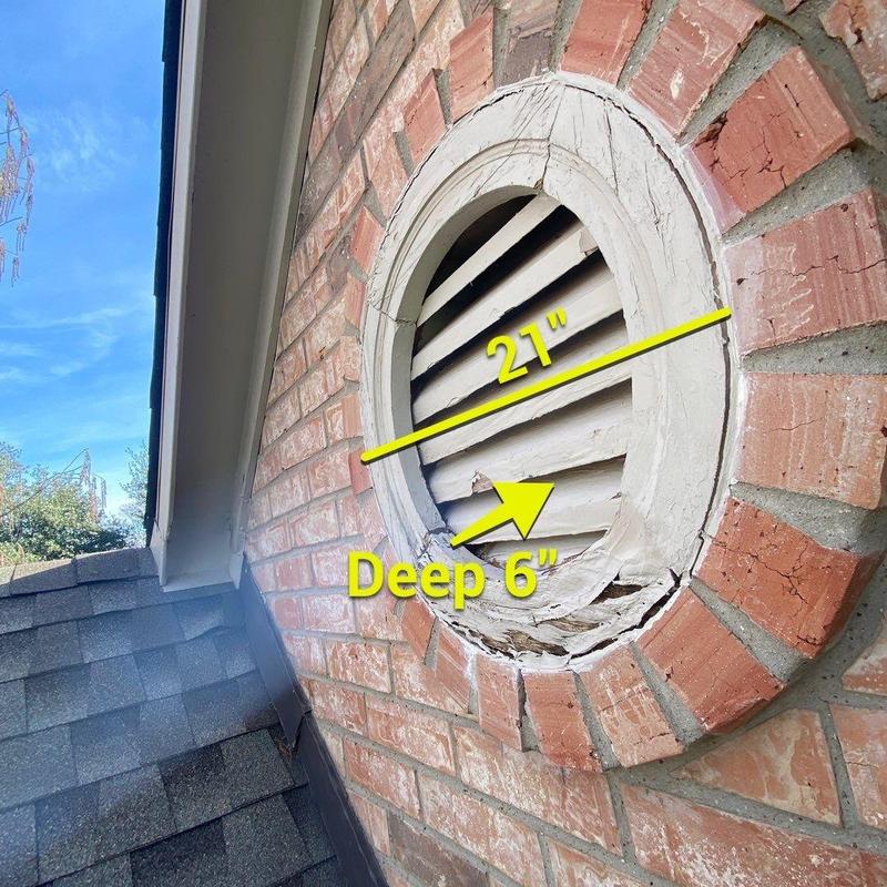 Rotting faux gable vent with measurements on brick wall